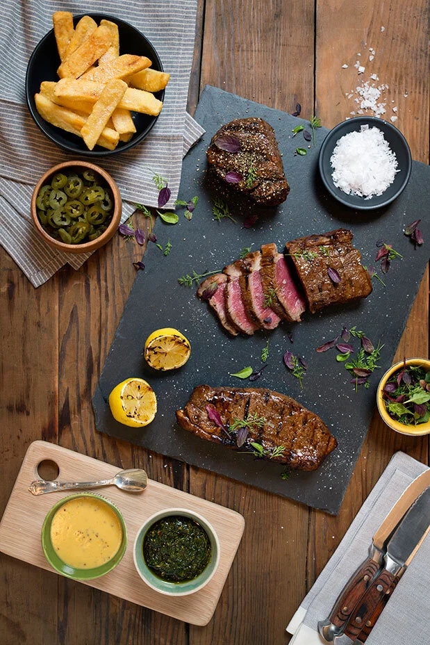 Steak selection and sides styled for Butcher Block Steakhouse. Food styling by Bianca Delides. Photographed by Rikki Hibbert.